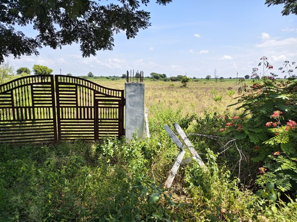 fenced farmland with gate in Andole Mandal